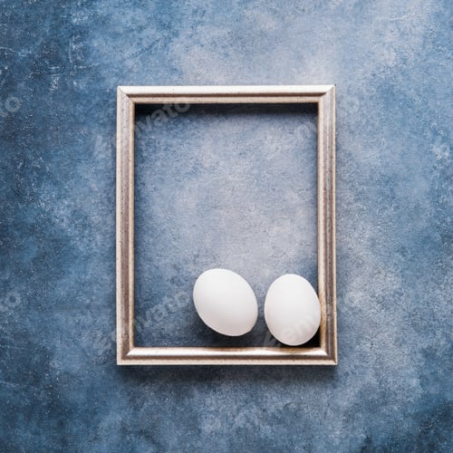 Preview: Easter Eggs and photo frame on a blue background. Top view, copy space. Easter celebration concept.