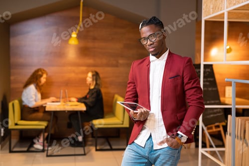 Preview: Handsome African student or contemporary businessman with touchpad