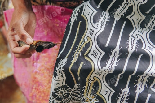Preview: Close up picture of drawing the design pattern of Indonesian batik tulis fabric with black color.