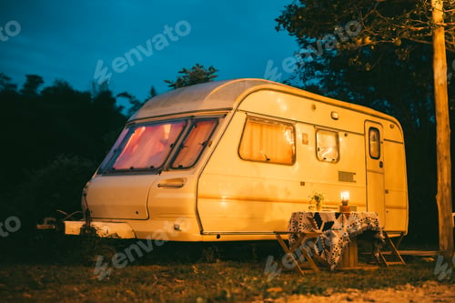 Preview: A small white trailer with a table and chairs outside