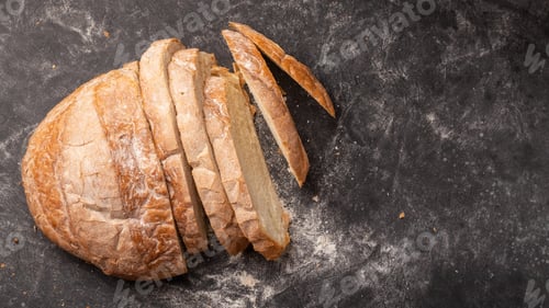 Preview: White round bread cut into many pieces, located on a black background and flour sprinkled.