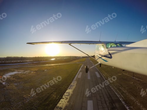 Preview: Small Airplane flying over the city during a vibrant winter sunset