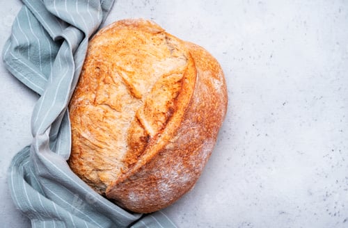 Preview: Homemade whole grain freshly baked wheat bread from sourdough. Gray background, top view