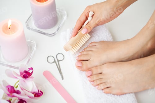 Preview: Cozy home spa, young woman doing pedicure on her feet nails.