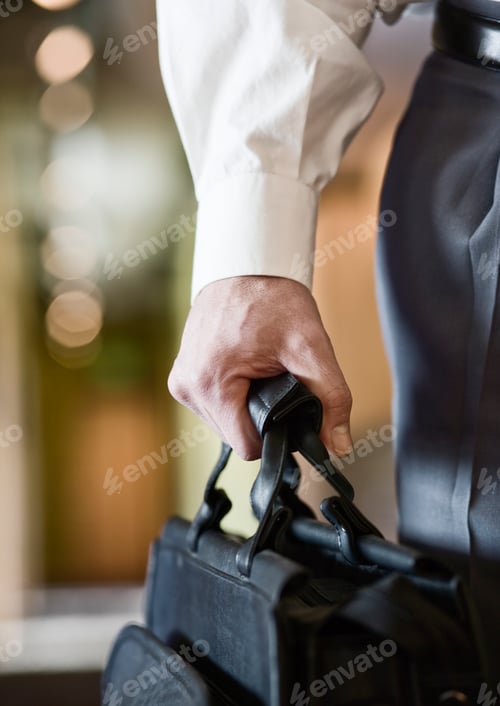 Preview: A closeup of the hand of a businessman holding a brief case.