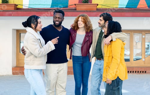 Preview: Group of multi-ethnic friends hugging and chatting in an urban environment