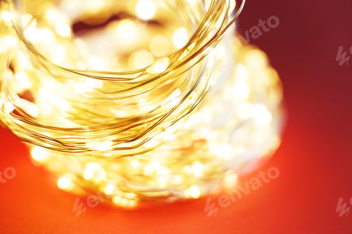Preview: christmas beautifull shiny gold garland on a red background. sparkle festive background