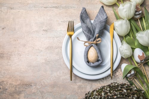 Preview: Easter holiday table setting with bunny from egg on white plate flowers.Happy Easter background