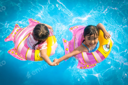 Preview: Two girls swimming with fish float in summer