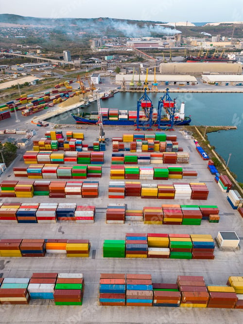 Preview: aerial view of a container ship in terminal at the port, where massive containers await their
