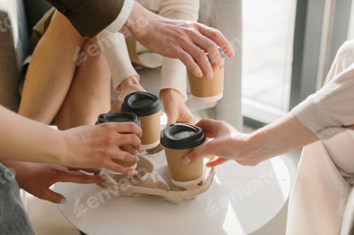 Preview: Business colleagues sharing coffee cups during meeting break