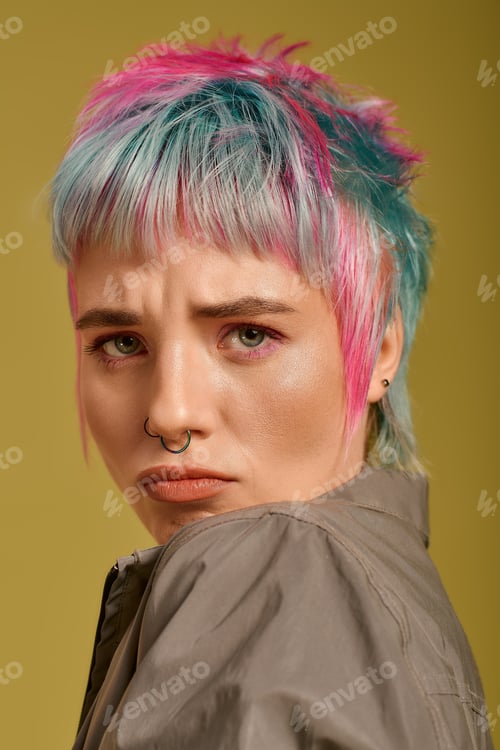 Preview: Young woman with vibrant dyed hair poses confidently in a creative studio setting