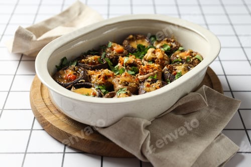 Preview: Stuffed mushrooms in baking tray on board and towel on light background