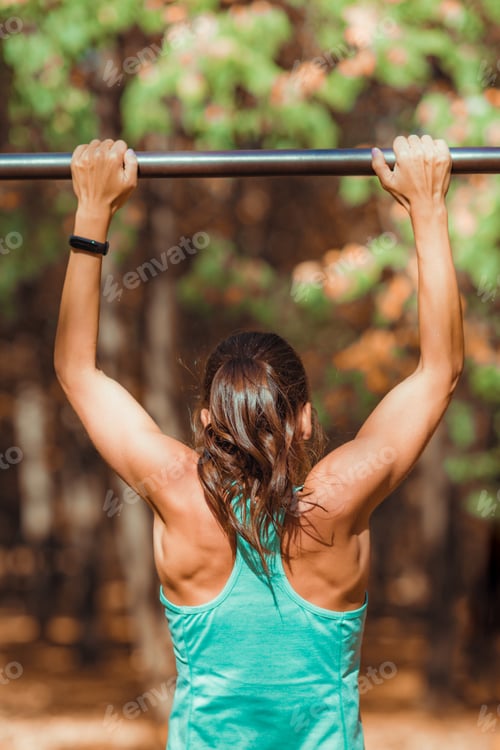 Preview: Woman doing pull-ups in the park