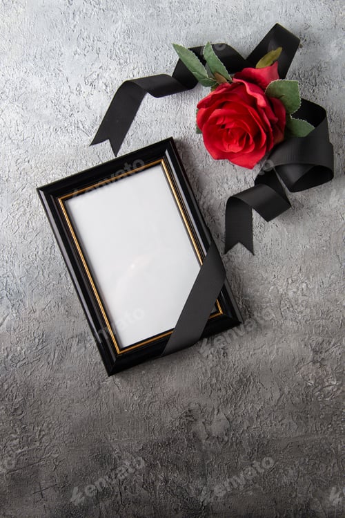 Preview: top view of red flower with picture frame on a light surface war death soldier