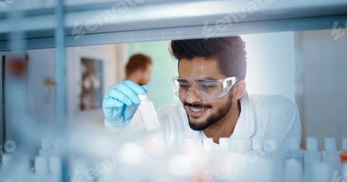 Preview: Male student of chemistry working in laboratory