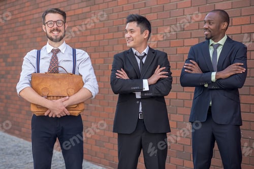 Preview: Portrait Of Multi Ethnic Business Team.Three Smiling Men Standing Against The Background Of Red