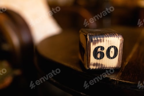 Visualização: O número 60 no cubo de madeira é queimado com símbolos grandes