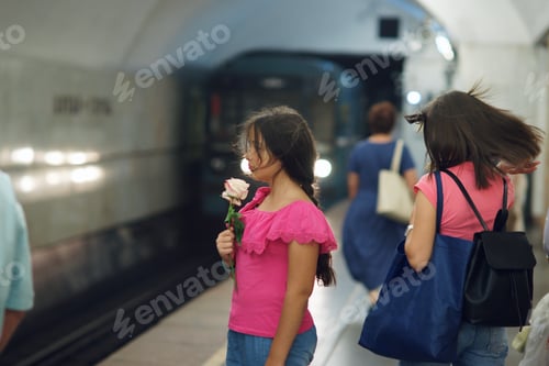 Preview: A teen girl with a rose in her hands stands in the subway waiting for the train.
