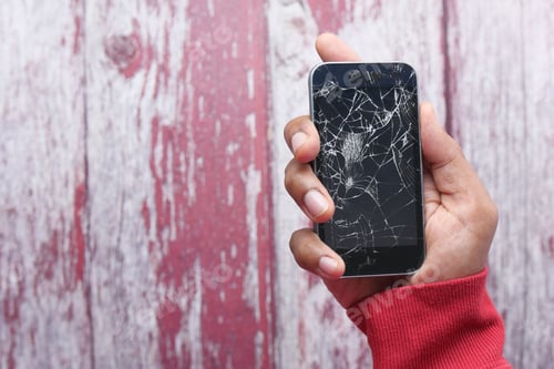 Preview: Close up of man hand holding broken smart phone.