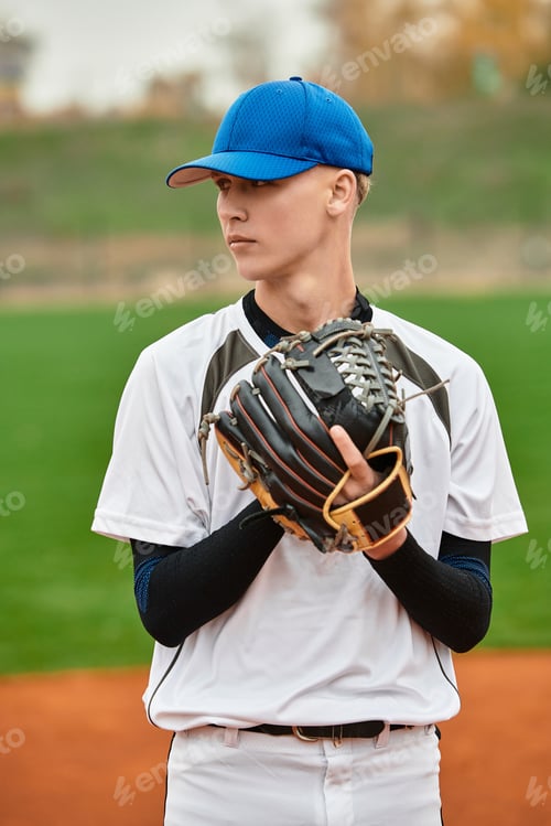 Preview: Talented teenage boy preparing to pitch on a bright baseball field at twilight