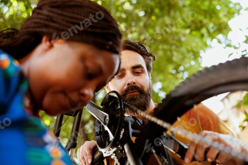 Preview: Multiracial couple maintaining bicycle