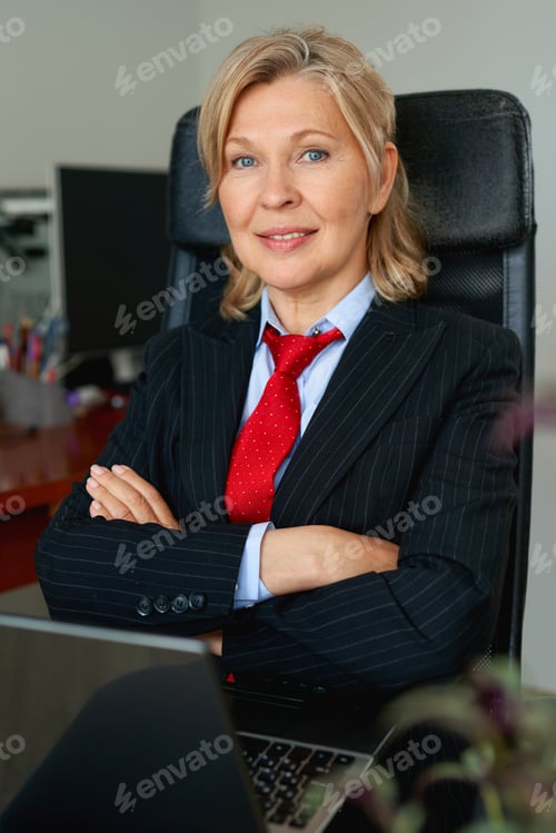 Preview: Portrait Of Mature Boss Woman In Red Tie At Office.