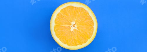 Preview: Top view of a one orange fruit slice on bright background in blue color. A satur