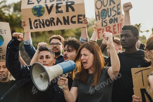 Preview: Group of multi ethnic eco activists with arms raised and clenched fists shouting into megaphone