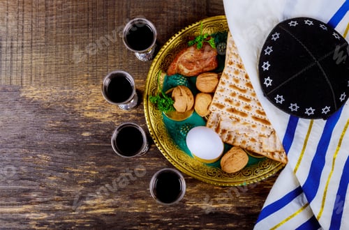 Preview: Symbols of Passover background four glasses wine and matzoh jewish holiday bread over wooden board.