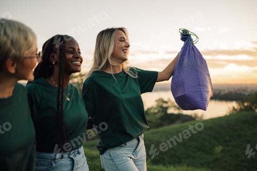 Preview: Three volunteers walking and holding trash bag in nature