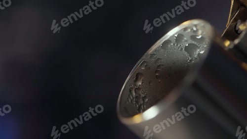 Preview: Extreme close up of steel kettle spout with drops of water on its surface. Action. Steam coming from
