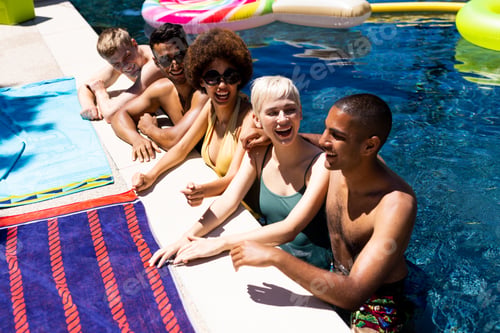 Preview: Happy diverse group of friends having pool party in garden