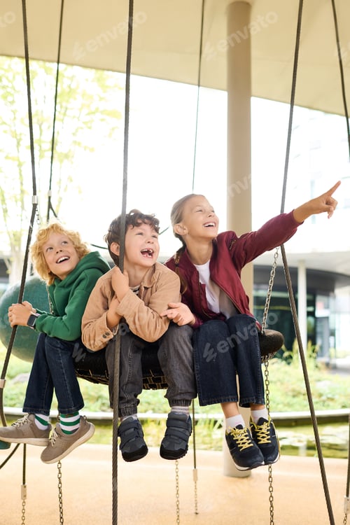 Preview: Joyful children playing on swings during a colorful autumn day in the park