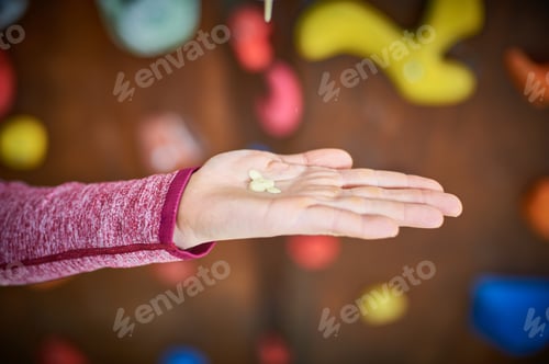 Visualização: Alpinista se prepara para a subida com giz na mão na academia coberta de escalada