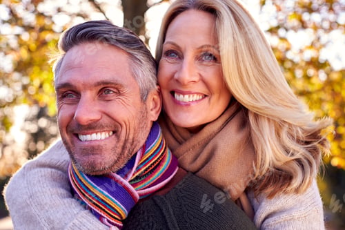 Preview: Loving Mature Woman Hugging Man From Behind As Retired Couple Walk Through Autumn Countryside