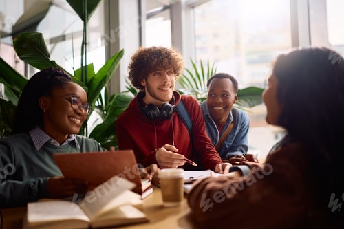 Preview: Happy student communicating with his friends while learning together at the university.
