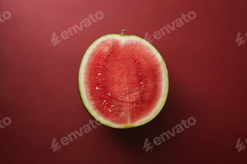 Preview: top view of half of watermelon on red surface