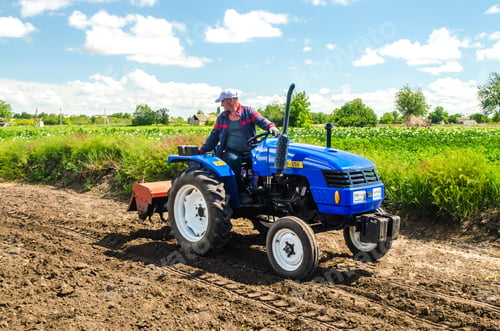Preview: Kherson oblast, Ukraine - May 28, 2020: A farmer with a cultivation unit on a tractor