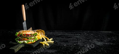Preview: Burger with a knife and fries.