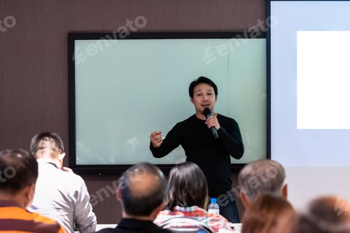 Preview: Man Speaking Into Microphone at Business Presentation