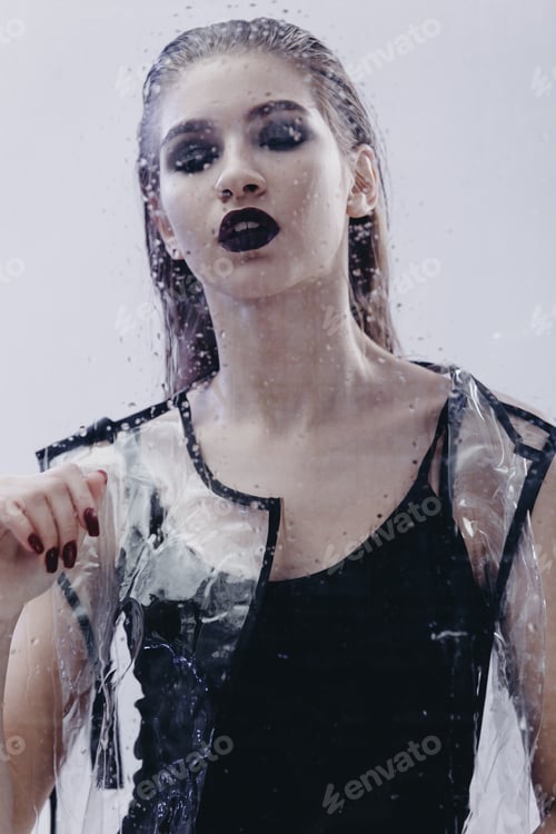 Preview: Young fashionable girl with wet hair and dark lipstick dressed in black swimming suit and