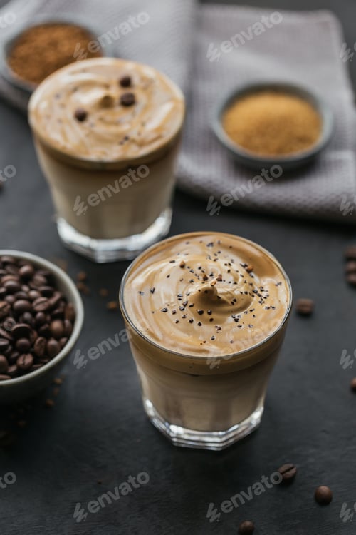 Preview: Glass of Iced Dalgona Coffee, trendy fluffy creamy whipped coffee and milk on black background.