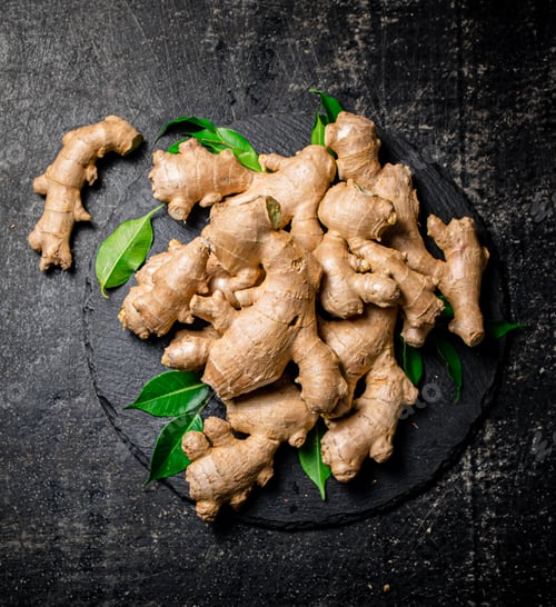 Preview: Fresh ginger with leaves on a stone board.