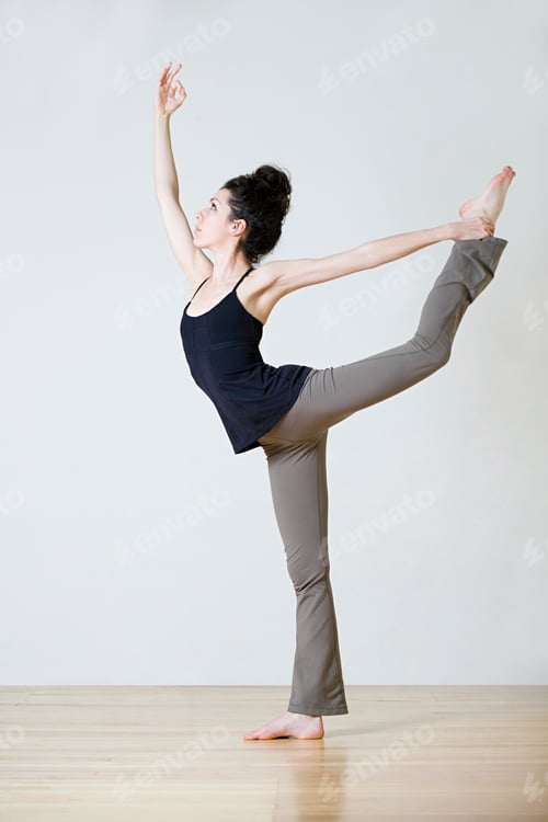 Preview: A graceful dancer performing a yoga pose on a wooden floor against a neutral background.