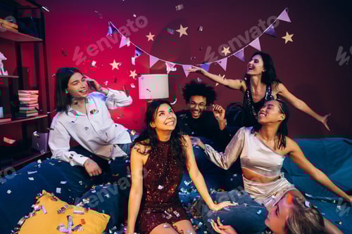 Preview: Diverse friends celebrating together, enjoying confetti at a party