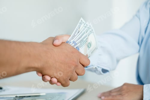 Preview: Photo of Businessmen shaking hands and dollar note, sign a contract to bribe corruption in the compa