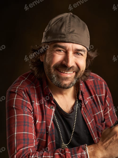 Preview: portrait of a happy man in a cap smiling and looking at the camera