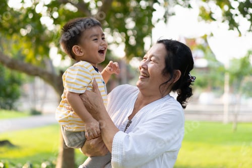 Preview: Asian grandmother is holding and playing with little grandson with happy moment in the green park