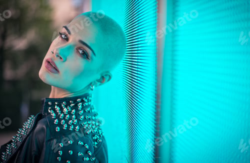 Preview: Image of a beautiful young woman posing against a led panel.